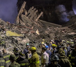 Workers stand at ground zero in New York, Sept. 12, 2001.