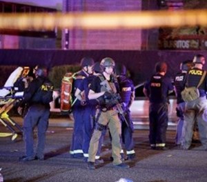 In this Oct. 2, 2017, file photo, police officers and medical personnel stand at the scene of the shooting near the Mandalay Bay resort and casino on the Las Vegas Strip in Las Vegas.