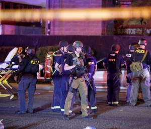 In this Oct. 2, 2017, file photo, police officers and medical personnel stand at the scene of a shooting near the Mandalay Bay resort and casino on the Las Vegas Strip in Las Vegas.