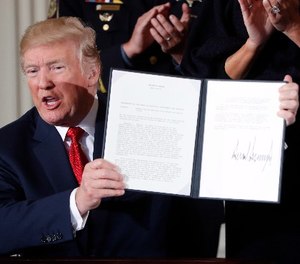 President Donald Trump displays a presidential memorandum he signed, declaring the opioid crisis a public health emergency in the East Room of the White House, Thursday, Oct. 26, 2017, in Washington. (AP Photo/Pablo Martinez Monsivais)