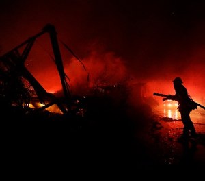 Fire crews work among destroyed homes at the Rancho Monserate Country Club community Thursday, Dec. 7, 2017, in Fallbrook, Calif.