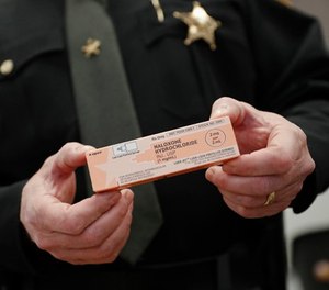 Captain Paul Kamphaus, of the Clermont County Sheriff's Office, handles a box of naloxone during an interview, Wednesday, Nov. 15, 2017, in Batavia, Ohio. (AP Photo/John Minchillo)