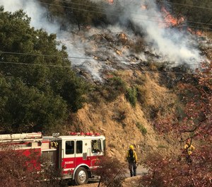 In this photo provided by the Santa Barbara County Fire Department, an engine company from the city of Colton, Calif., operating under mutual aid, keeps watch on pockets of burning and unburned vegetation off Bella Vista Dr. in Montecito, Calif., Wednesday, Dec. 13, 2017.