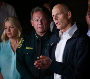 Florida Gov. Rick Scott, foreground, speaks along with Sheriff Scott Israel, center, of Broward County, and Pam Bondi, Florida Attorney General, during a news conference near Marjory Stoneman Douglas High School in Parkland, Fla., Wednesday, Feb. 14, 2018. (AP Photo/Wilfredo Lee)