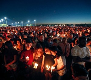 People attend a candlelight vigil for the victims of the Wednesday shooting at Marjory Stoneman Douglas High School, in Parkland, Fla., Thursday, Feb. 15, 2018. (AP Photo/Gerald Herbert)