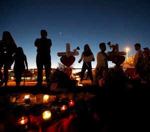 People visit a makeshift memorial outside Marjory Stoneman Douglas High School, where 17 students and faculty were killed in a mass shooting in Parkland, Fla., Sunday, Feb. 18, 2018. (AP Photo/Gerald Herbert)