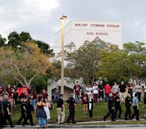 Police walk outside Marjory Stoneman Douglas High School in Parkland, Fla., Wednesday, Feb. 28, 2018. (AP Photo/Terry Renna)