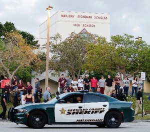 A police car drives by Marjory Stoneman Douglas High School in Parkland, Fla., Wednesday, Feb. 28, 2018. (AP Photo/Terry Renna)
