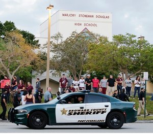 A patrol car drives by Marjory Stoneman Douglas High School in Parkland, Fla., Wednesday, Feb. 28, 2018.