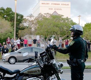 A police officer stands watch at Marjory Stoneman Douglas High School in Parkland, Fla., Wednesday, Feb. 28, 2018.