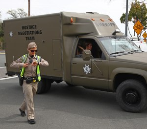 A sheriff's hostage negotiation team passes a checkpoint at the Veterans Home of California in Yountville, Calif. Authorities say a combat veteran shot himself in the head with a shotgun after fatally shooting three mental health workers on March 9, 2018.