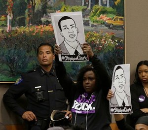 In this March 27, 2018, file photo, drawings of Stephon Clark are held up next to Sacramento Police Chief Daniel Hahn, left, during a meeting of the Sacramento City Council held to discuss the shooting, in Sacramento, Calif.