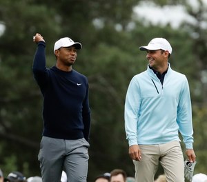 Tiger Woods, Matt Parziale and Fred Couples walk up the first fairway during a practice round for the Masters golf tournament Wednesday, April 4, 2018, in Augusta, Ga.