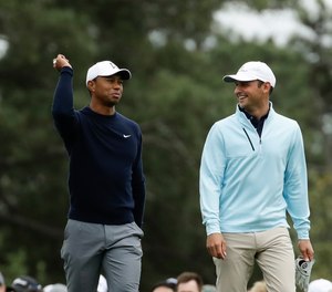 Tiger Woods, Matt Parziale and Fred Couples walk up the first fairway during a practice round for the Masters golf tournament Wednesday, April 4, 2018, in Augusta, Ga.