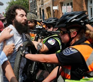 A demonstrator confronts police on the anniversary of the Unite the Right rally in Charlottesville, Va., Sunday, Aug. 12, 2018.