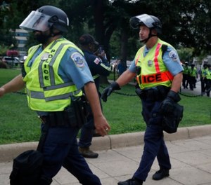 Washington Metropolitan Police in riot gear walk near the White House on the one year anniversary of the Charlottesville 