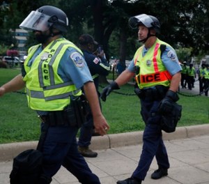 Washington Metropolitan Police in riot gear walk near the White House on the one year anniversary of the Charlottesville