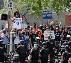 Police form a barrier to keep counter-protesters separated from members of Patriot Prayer and other groups supporting gun rights march during a rally, Saturday, Aug. 18, 2018, at City Hall in Seattle.