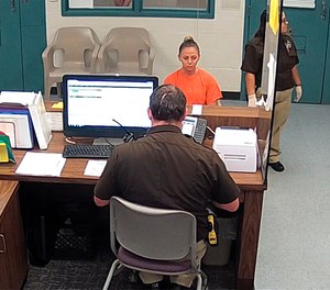 This photo from video released Thursday, Sept. 13, 2018, by the Kaufman County Sheriff's Office in Kaufman, Texas, shows Dallas police Officer Amber Guyger getting booked after turning herself in Sunday, Sept. 9 following the fatal shooting of Botham Jean in his own apartment. Guyger was arrested manslaughter and has since been released on bond.