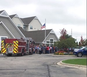 A fire truck and people evacuated are gathered at a hotel near the scene after a shooting was reported at a software company in Middleton, Wis., Wednesday, Sept. 19, 2018. Multiple were reported to have been shot. (AP Photo/Todd Richmond)