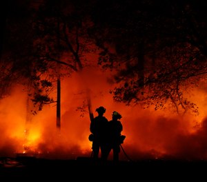 Firefighters work on a controlled burn at the Camp Fire, Friday, Nov. 9, 2018, in Magalia, Calif.