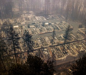 In this Thursday, Nov. 15, 2018, file photo, residences leveled by the wildfire line a neighborhood in Paradise, Calif. Northern California crews battling the country's deadliest wildfire in a century were bracing for strong winds Sunday, Nov. 18, that could erode gains they have made in containing the fearsome blaze, which has killed dozens and leveled a town. (AP Photo/Noah Berger, File)