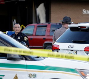 Law enforcement officials stand out in front of a SunTrust Bank branch, Wednesday, Jan. 23, 2019, in Sebring, Fla., where authorities say five people were shot and killed.