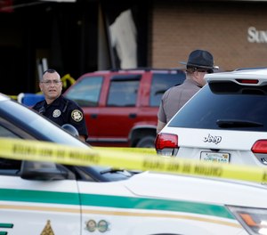 Law enforcement officials stand out in front of a SunTrust Bank branch, Wednesday, Jan. 23, 2019, in Sebring, Fla., where authorities say five people were shot and killed.