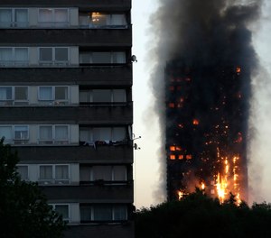 In this Wednesday, June 14, 2017 file photo, smoke and flames rise from the Grenfell Tower, in London. Police investigating a blaze that killed 72 people in a London tower block two years ago say no one is likely to face criminal charges until 2021.