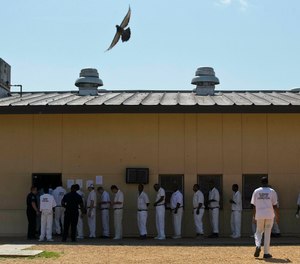 In this June 18, 2015, file photo, prisoners stand in a crowded lunch line during a prison tour at Elmore Correctional Facility in Elmore, Ala.