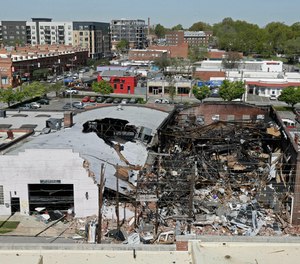 Charred remains are piled in a heap of rubble the day after an explosion and building fire caused by a gas leak killed one person and injured more than two dozen, including nine firefighters.