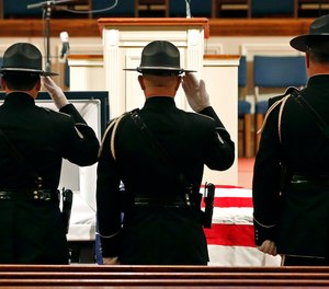 Members of the Biloxi Police Department Honor Guard salute the body of officer Robert McKeithen after escorting him into the First Baptist Church of Biloxi, Miss., Monday, May 13, 2019, prior to visitation. McKeithen was killed outside Biloxi's police station May 5.