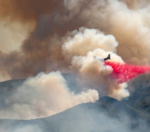 A plane drops fire retardant on a hillside in an attempt to box in flames from a wildfire during the Sand Fire in Rumsey, Calif.