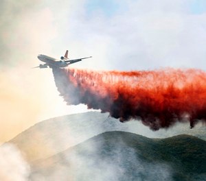 A plane drops fire retardant on a hillside in an attempt to box in flames from a wildfire during the Sand Fire in Rumsey, Calif. (AP Photo/Josh Edelson)