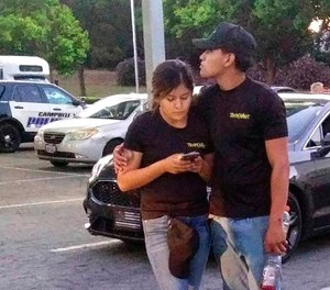 A young couple embrace at a parking lot after a shooting at the Gilroy Garlic Festival in Gilroy, Calif., Sunday, July 28, 2019. Several people were hospitalized Sunday after the shooting at the annual food festival in Northern California, a hospital spokeswoman said. (AP Photo/Thomas Mendoza)