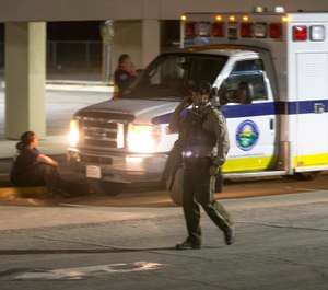 A police officer dressed in SWAT gear walks through the first aid center at Gilroy High School following a shooting at the Gilroy Garlic Festival in Gilroy, Calif., on Sunday July 28, 2019. (AP Photo/David Royal)