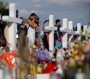 People visit a makeshift memorial, Monday, Aug. 5, 2019, at the site of a mass shooting at a shopping complex, in El Paso, Texas.