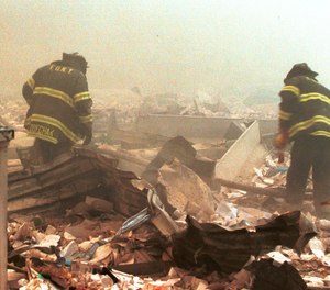 Firefighters sift through wreckage from the World Trade Center on Sept. 11, 2001.