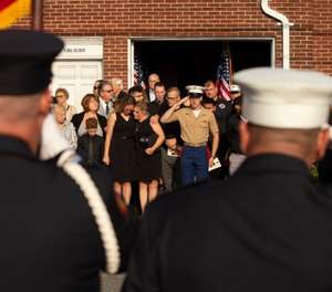 Kiersten Haub, center left, hugs her mother Erika Starke, center, as Michael Haub, center right, salutes for New York firefighter Michael Haub, as they attend a second funeral service for him in Franklin Square, N.Y. (Photo/AP, Eduardo Munoz Alvarez)