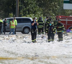 Firefighters looks through debris at the scene of an explosion Monday, Sept. 16, 2019, in Farmington, Maine. The town of Farmington faces $22,000 in fines from the Maine Department of Labor, which says firefighters who went to investigate an initial gas leak at the site did not have proper training or equipment. (AP Photo/Robert F. Bukaty)