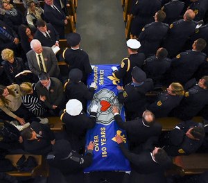 Pall bearers carry the casket of Worcester firefighter Lt. Jason Menard into his funeral mass in St. John's Church in Worcester, Mass. Monday Nov. 18, 2019. Mourners from fire departments across the region are expected at the funeral of the fire lieutenant who died after saving two colleagues.