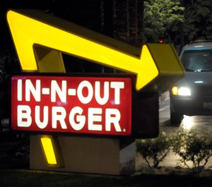 In this June 8, 2010, file photo, a customer receives an order from the drive-through at an In-N-Out Burger in Baldwin Park, Calif. CAL FIRE alleges that fast food chain In-N-Out was responsible for a 2017 wildfire in rural Arroyo Grande, Calif., according to a lawsuit filed in San Luis Obispo Superior Court. (AP Photo/Adam Lau, File)