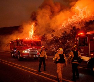 Firefighters battle the Cave Fire burn as it flares up along Highway 154 in the Los Padres National Forest, above Santa Barbara, Calif., Tuesday, Nov. 26, 2019.