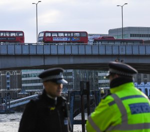 Buses and cars remain on London Bridge in London after a convicted terrorist who had been let out of prison in an automatic release program stabbed to death two people and wounded three others in a knife attack on Nov. 29, 2019. (AP Photo/Alberto Pezzali)