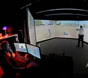 An officer takes part in a police training exercise using an immersive VirTra virtual firearms training simulator.