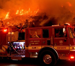 In this Nov. 26, 2019, file photo a firefighter prepares to battle the Cave Fire as it flares up along Highway 154 in the Los Padres National Forest, above Santa Barbara, Calif.
