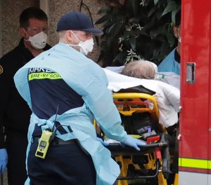 A patient is loaded into an ambulance, Tuesday, March 10, 2020, at the Life Care Center in Kirkland, Wash., near Seattle. The nursing home is at the center of the outbreak of the coronavirus in Washington state.