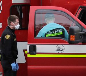Kirkland Fire and Rescue ambulance workers work near an ambulance after a patient was loaded for transport, Tuesday, March 10, 2020, at the Life Care Center in Kirkland, Wash., near Seattle.