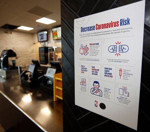 A sign warning about the risks of coronavirus hangs next to a food stand on the main concourse of Pepsi Center before an NHL hockey game between the New York Rangers and the Colorado Avalanche Wednesday, March 11, 2020, in Denver.