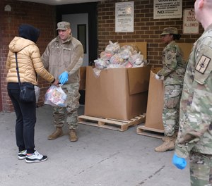 Members of the New York National Guard distribute food to families in New Rochelle, N.Y., Thursday, March 12, 2020. The area endured a fast-growing COVID-19 cluster, which led to Gov. Andrew Cuomo declaring a 1-mile radius “containment area” in the New York suburb.